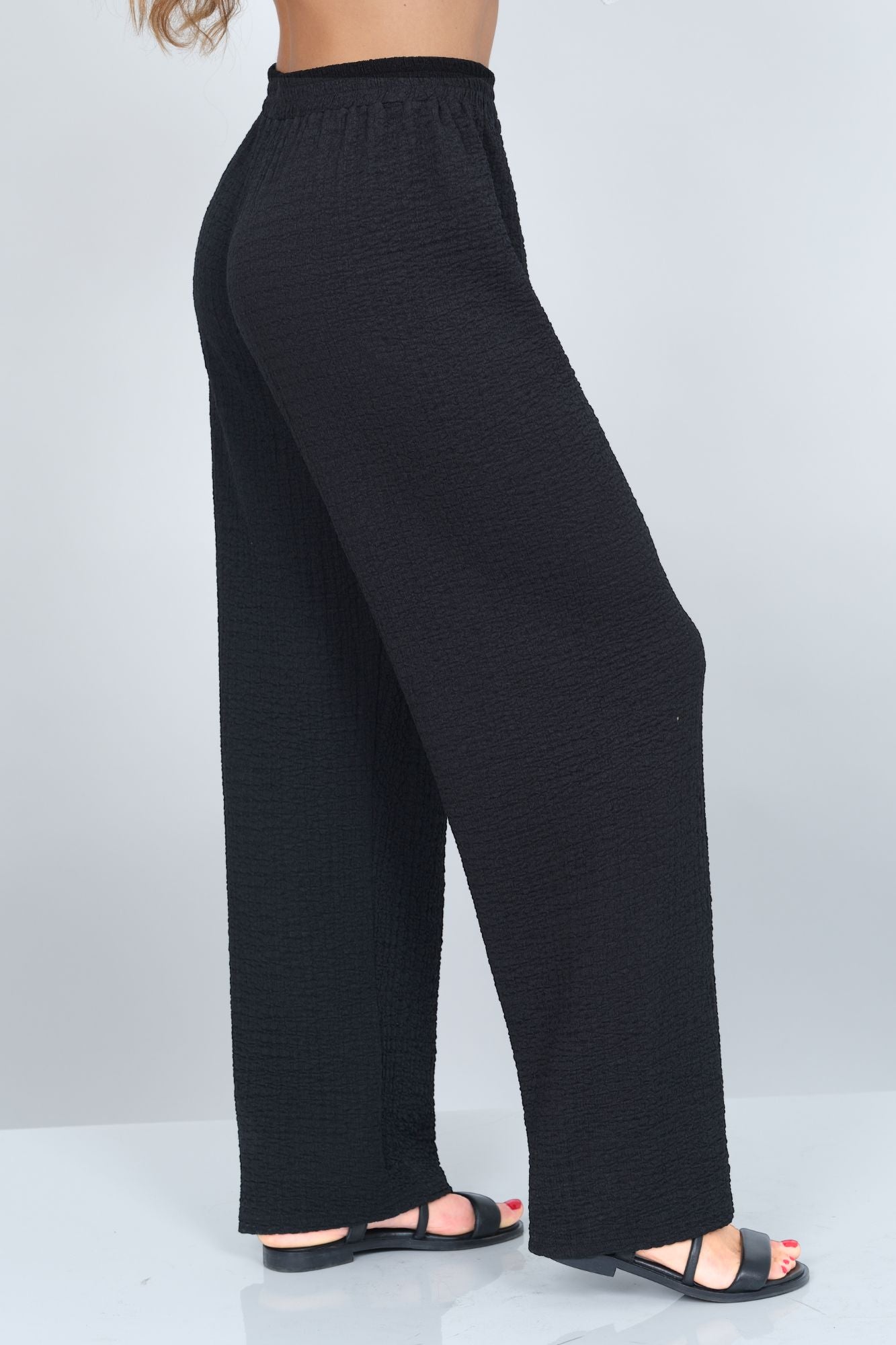 Black wide-leg pants worn by a person on a white background